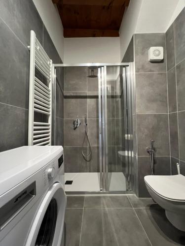 y baño con ducha y lavadora. en LA VOLTA - ANTESITUM - historic, on the lake, en Malgrate
