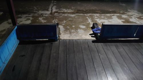 dos bancos azules sentados en una terraza de madera en RISKY HOUSE, en Sampit