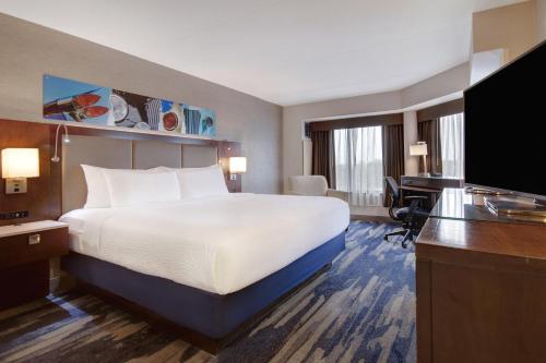 Pokój hotelowy z dużym łóżkiem i biurkiem w obiekcie Crowne Plaza Auburn Hills, an IHG Hotel w mieście Auburn Hills