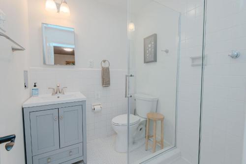 a bathroom with a toilet and a glass shower at Marys Gatehouse Garden Apartment in Greensboro