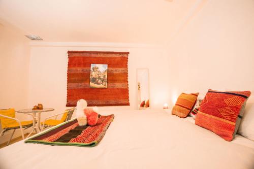 RumiUma Boutique Hotel في كوسكو: غرفة نوم بسرير مع طاولة وكراسي
