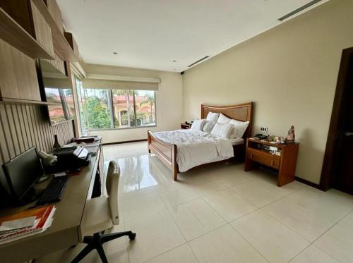 a bedroom with a bed and a desk with a computer at casa en samborondon in Guayaquil