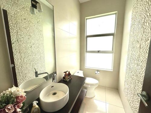 a bathroom with a sink and a toilet and a window at casa en samborondon in Guayaquil