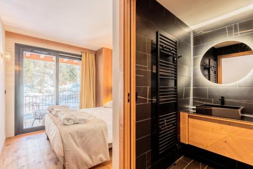 a bathroom with a bed and a sink in a room at Résidence LES CRISTAUX - Duplex CRISTAUX C 764 in Bourg-Saint-Maurice