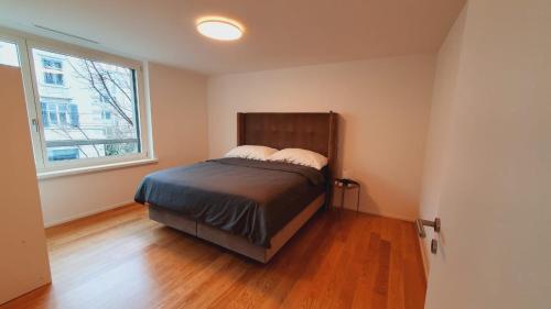 - une chambre avec un lit et une fenêtre dans l'établissement DHG Luxury Apartments Zurich-Wollishofen, à Zurich