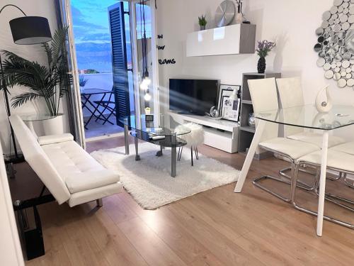 a dining room with a glass table and white chairs at Apartment New Chic in Supetar