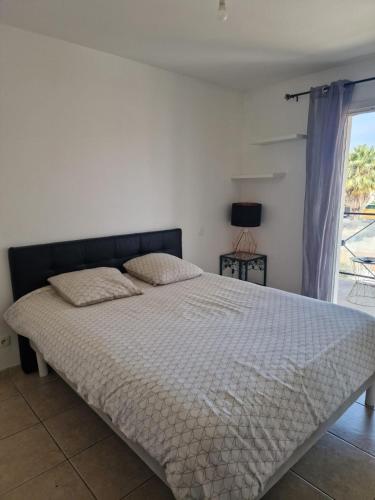 une chambre avec un grand lit avec une fenêtre dans l'établissement VILLA FAMILIALE AVEC PISCINE PROCHE DE TOUTES LES PLAGES, à Villeneuve-lès-Maguelone