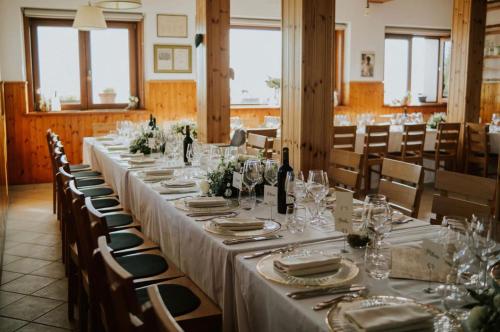 a long table with white table cloth and wine glasses at Rifugio Guglielmo e Giovanni Pelizzo in Montemaggiore