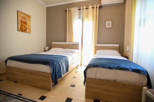 two beds sitting next to each other in a bedroom at Villa Solitude in Berat