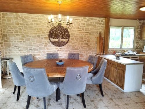 a dining room with a wooden table and chairs at Maison familiale chaleureuse à Paimpont, 130 m² avec jardin in Paimpont