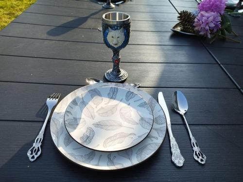 a plate on a table with a wine glass and silverware at Maison familiale chaleureuse à Paimpont, 130 m² avec jardin in Paimpont
