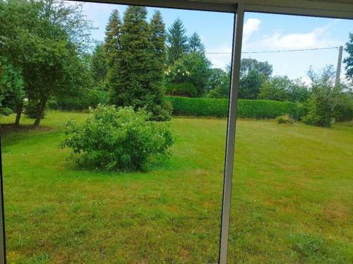 a view out of a window of a yard at Maison familiale chaleureuse à Paimpont, 130 m² avec jardin in Paimpont
