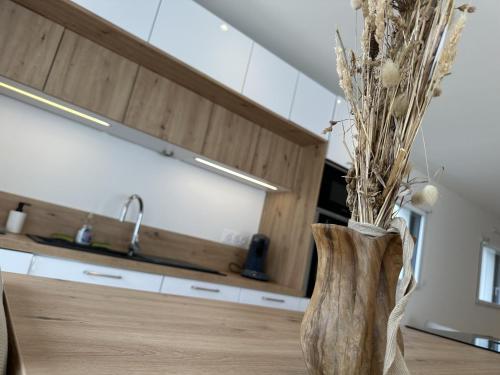 un vase avec des fleurs assis sur une table dans une cuisine dans l'établissement Le Ruffa, à Bohars