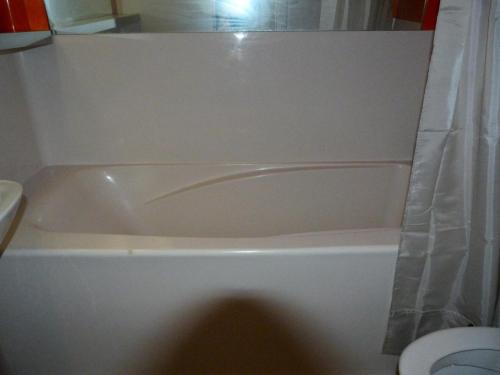 La salle de bains est pourvue d'une baignoire blanche et de toilettes. dans l'établissement Résidence Aiguille Grive Bat I - Duplex pour 5 personnes à Arc 1800 dans le village de Charmettoger, skis aux pieds MAE-1921, à Arc 1800