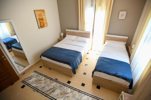 a small bedroom with two beds and a mirror at Villa Solitude in Berat