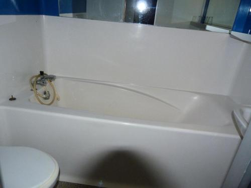 La salle de bains est pourvue d'une baignoire blanche et de toilettes. dans l'établissement Résidence Archeboc - Appartement 5 personnes à Arc 1800 proche des pistes dans le village de Charmettoger MAE-1925, à Arc 1800