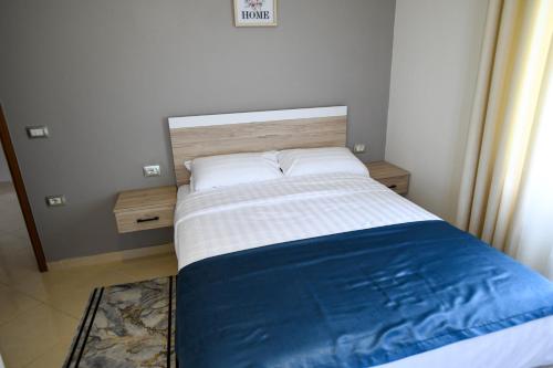a bedroom with a bed with a blue and white blanket at Villa Solitude in Berat