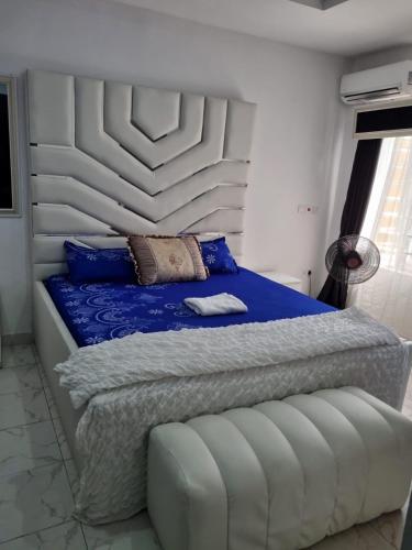 Schlafzimmer mit einem Bett mit einem weißen Kopfteil in der Unterkunft Pentagon Court Phase 1 Apartment Ikota in Lagos