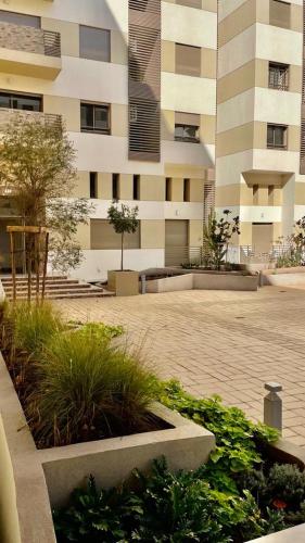 un bâtiment avec une cour avec des plantes devant lui dans l'établissement Property management aéroport med V international, à Dah Hammou Ben Cheïkh