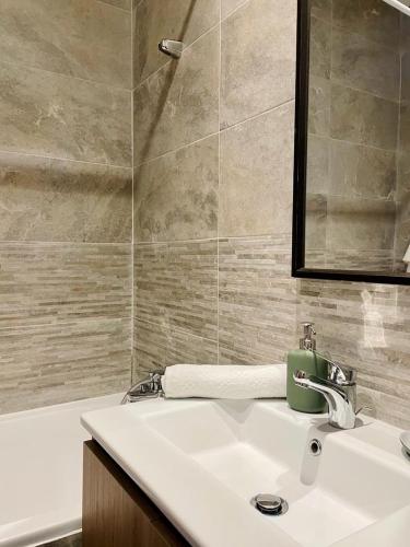La salle de bains est pourvue d'un lavabo, d'un miroir et d'une baignoire. dans l'établissement Property management aéroport med V international, à Dah Hammou Ben Cheïkh