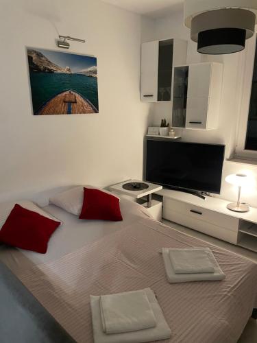 斯普利特的住宿－Apartment “Jelin dvor” 3+2, Bacvice, Split，一间卧室配有一张带红色枕头的大床