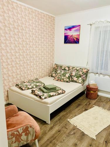 een kleine slaapkamer met een bed en een stoel bij ÉDES ÁLOM VENDÉGHÁZ in Szekszárd