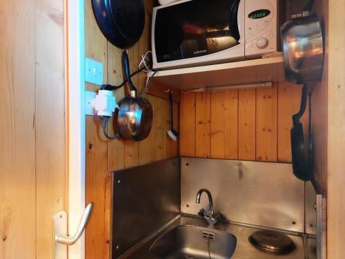 une petite cuisine avec un évier et un micro-ondes dans l'établissement Résidence Nova - Studio 2 personnes, proche des pistes et des commerces, au cœur de la station d’Arc 1800 dans le village des Villards MAE-1988, à Arc 1800