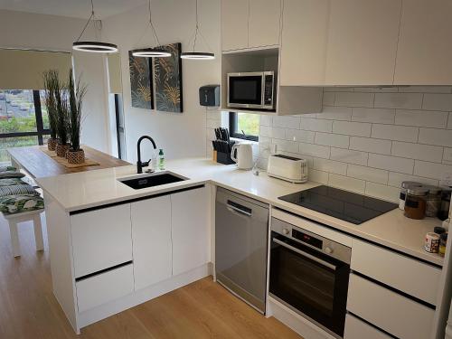 a kitchen with a sink and a stove top oven at Flat Bush Holiday Accomodation in Auckland