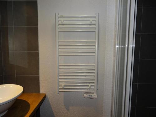 een badkamer met een wastafel en een wit handdoekenrek bij Résidence Roc Belleface C - 3 Pièces pour 8 Personnes 98 in Arc 1600
