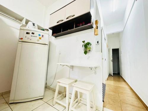eine kleine Küche mit einem Kühlschrank und 2 Hockern in der Unterkunft Práctico apto em Ipanema para descansar in Rio de Janeiro
