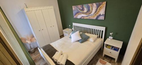 una piccola camera da letto con un letto con lenzuola e cuscini bianchi di Los Almendr2s a Frontera