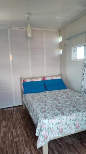 a bedroom with a bed with blue pillows at Pousada PETIT CHALET Canoa Quebrada in Canoa Quebrada