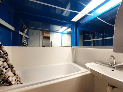 uma casa de banho com uma banheira, um lavatório e tectos azuis em Résidence Archeboc - 3 Pièces pour 6 Personnes 23 em Arc 1800