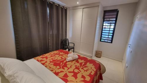 1 dormitorio con 1 cama con manta roja y amarilla en Raahere Lodge - near the city center, en Papeete