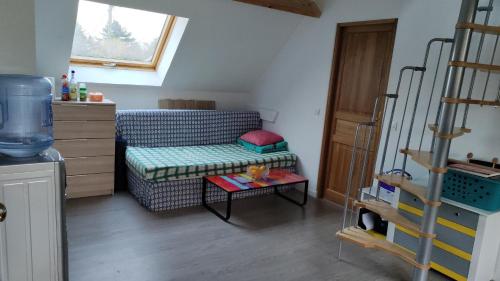 ein kleines Zimmer mit einem Sofa und einem Tisch in der Unterkunft Homestay chez Lien proche RER B in Bures-sur-Yvette