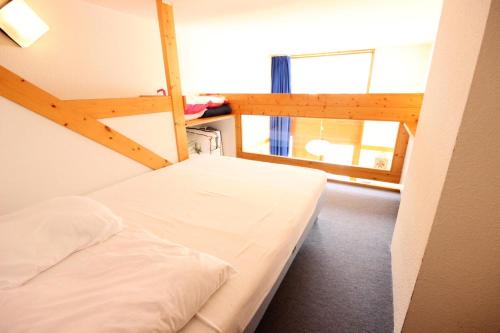 een slaapkamer met een wit bed en een ladder bij Résidence Arc En Ciel - 2 Pièces pour 5 Personnes 63 in Peisey-Nancroix
