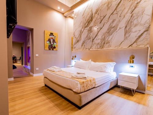 1 dormitorio con 1 cama grande y pared de mármol en Maximum hub suite&spa, en Palermo