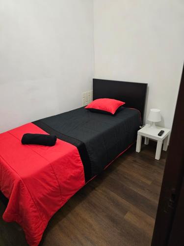 Reis Apartment في بورتو: غرفة نوم بسرير وبطانية حمراء وسوداء