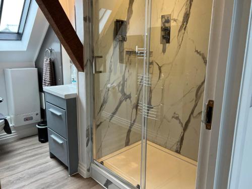 une douche avec une porte vitrée dans une salle de bain dans l'établissement Glastonbury Secret Retreat - 1 BD Split-Level Apt, Sleeps 3, à Glastonbury