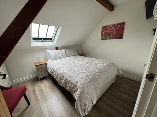 ein kleines Schlafzimmer mit einem Bett und einem Fenster in der Unterkunft Glastonbury Town Centre - Split-Level 1 Bedroom Apartment in Glastonbury