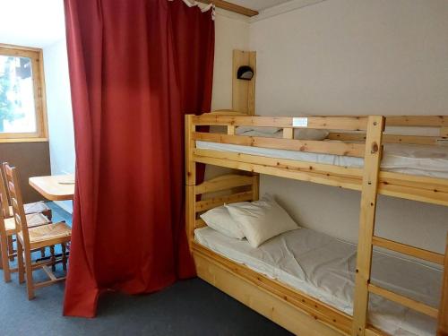 une chambre avec deux lits superposés et une table dans l'établissement Résidence Belles Challes - Studio 4 personnes à Arc 1800 skis aux pieds et proche des commerces dans le village du Charvet MAE-2131, à Arc 1800