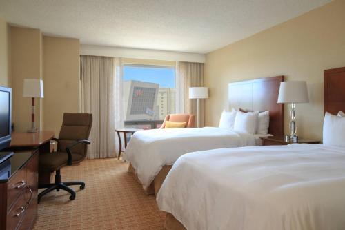 Cette chambre comprend deux lits et une télévision. dans l'établissement Gaithersburg Marriott Washingtonian Center, à Gaithersburg