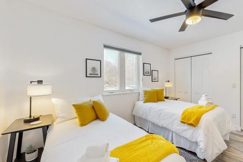 Un dormitorio con dos camas y un ventilador de techo. en Serenity Acres, en Douglas Center