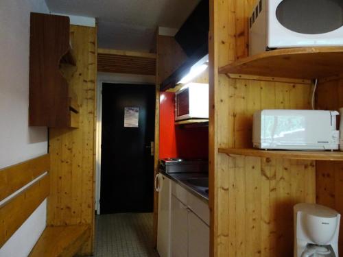 - une petite cuisine avec des murs en bois et un comptoir dans l'établissement Résidence Cascade - Grand studio 3 personnes à Arc 1600, ski aux pieds et proche des commerces MAE-2148, à Arc 1600