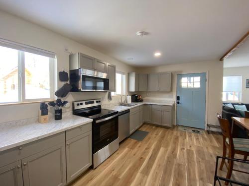 a kitchen with stainless steel appliances and wooden floors at Talkeetna Bush Pilot House in Talkeetna