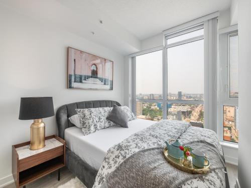 a bedroom with a bed with a view of the city at Designer One Bedroom Suite - Entertainment District Toronto in Toronto