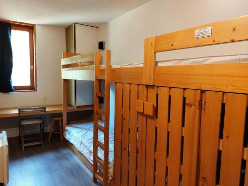 une chambre avec deux lits superposés et un bureau dans l'établissement Résidence Nova - Appartement 3 pièces 7 personnes, proche des pistes, des commerces, de la garderie et de l'ESF au centre de la station d’Arc 180 MAE-2174, à Arc 1800