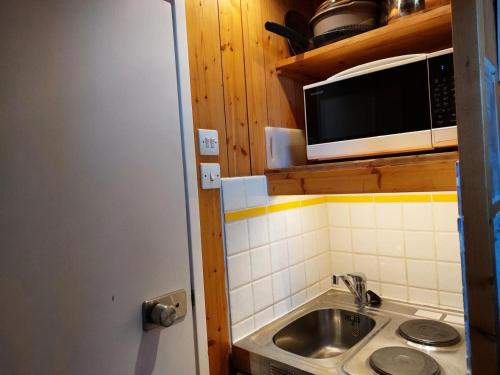 a kitchen with a sink and a microwave at Résidence Nova - Studio pour 2 personnes, au coeur de la station d'Arc 1800 dans le village des Villards MAE-2221 in Arc 1800
