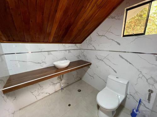 uma casa de banho com WC e uma tigela numa prateleira em Casa de Campo Oro Verde San Jose em Oxapampa