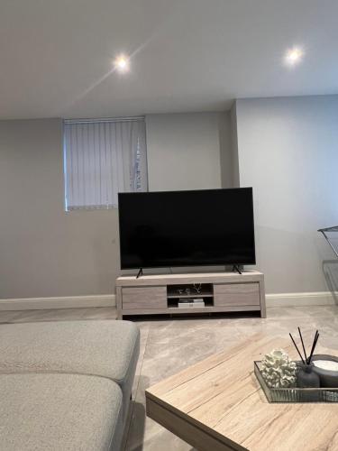 salon z dużym telewizorem z płaskim ekranem w obiekcie 3 Bedroom, Modern Flat In London w mieście Greenford